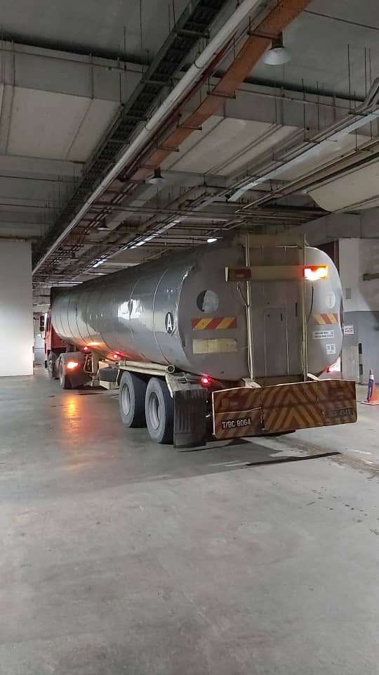 Water tanker positioned inside a restricted receiving area